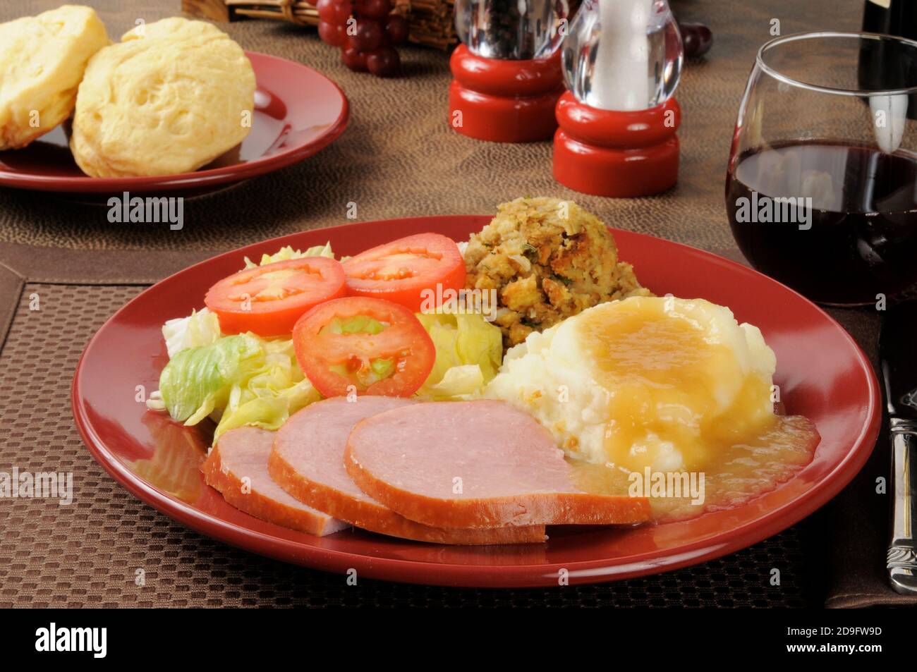 Ham dinner with cornbread stuffing, mashed potatoes and gravy Stock