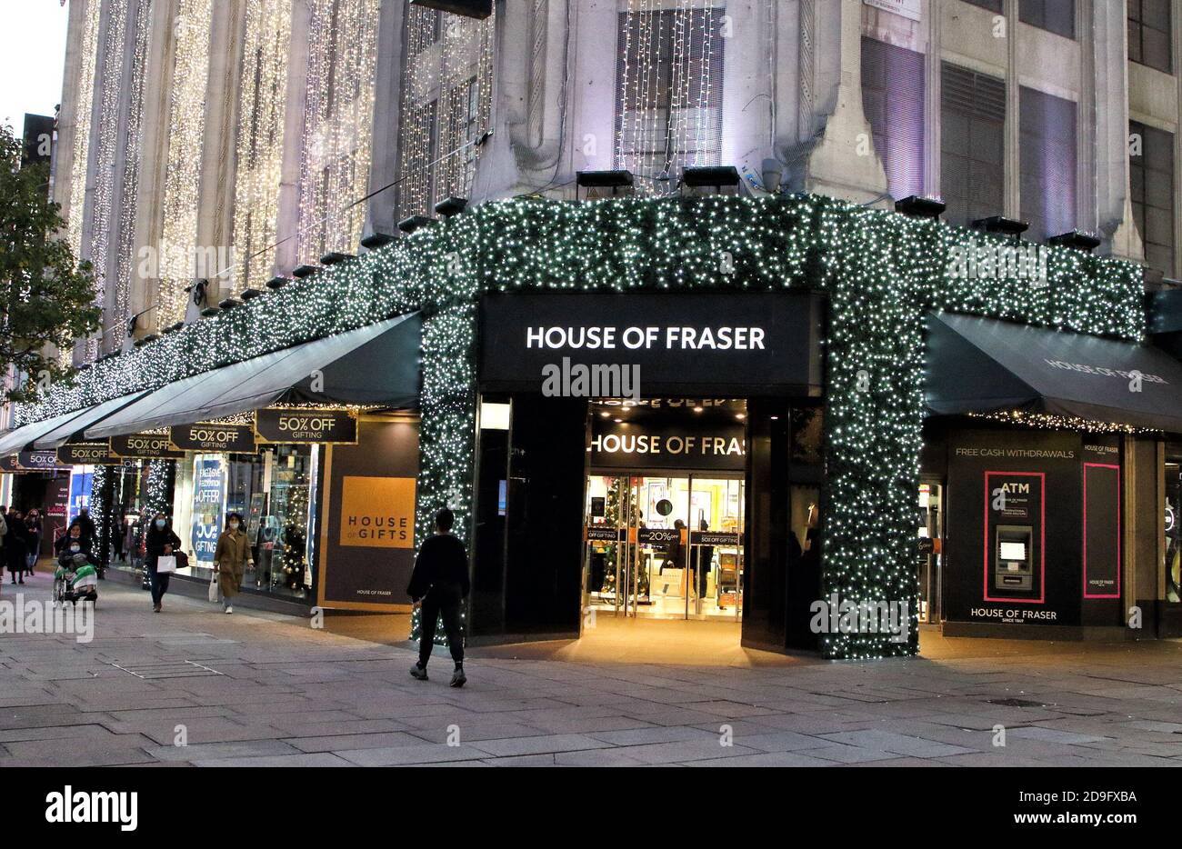 A woman walks past the Flagship Oxford Street House of Fraser store all  decorated with Christmas lights.House of Fraser Department store in Oxford  Street all lit up for Christmas, despite all non