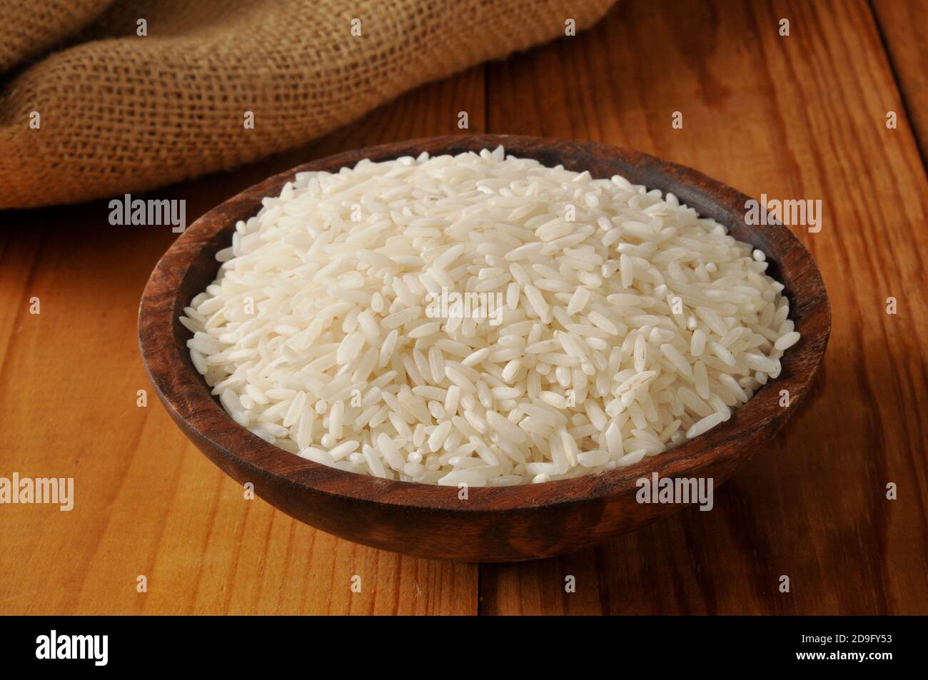 A wooden bowl of long grain white rice Stock Photo