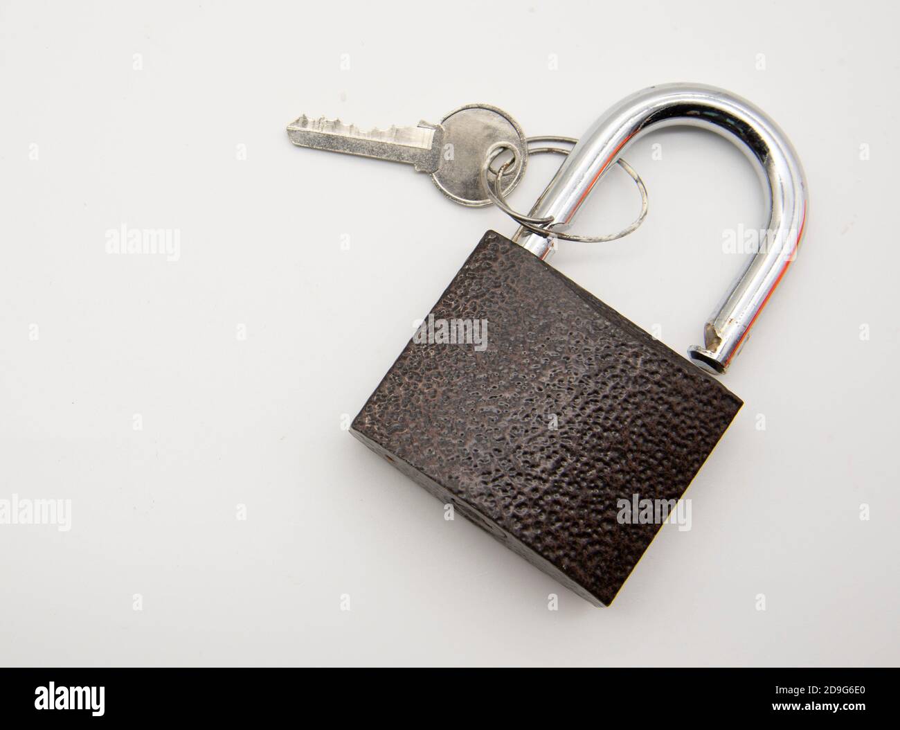 Metal padlock with key on white background Stock Photo - Alamy