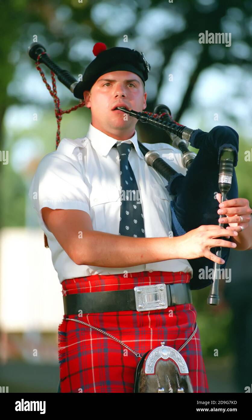 Portrait of a male in full Scottish dress playing music on the bag pipes Stock Photo