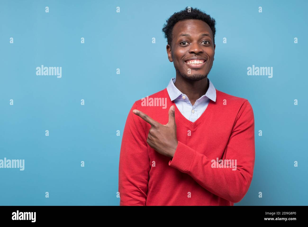 Smiling african american man pointing aside at copy space Stock Photo