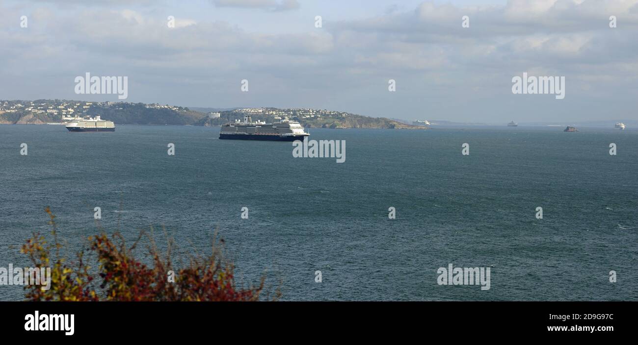 Two Holland America Line cruise ships anchored in Tor Bay during the coronavirus pandemic, looking towards Torquay from Berry Head. Stock Photo