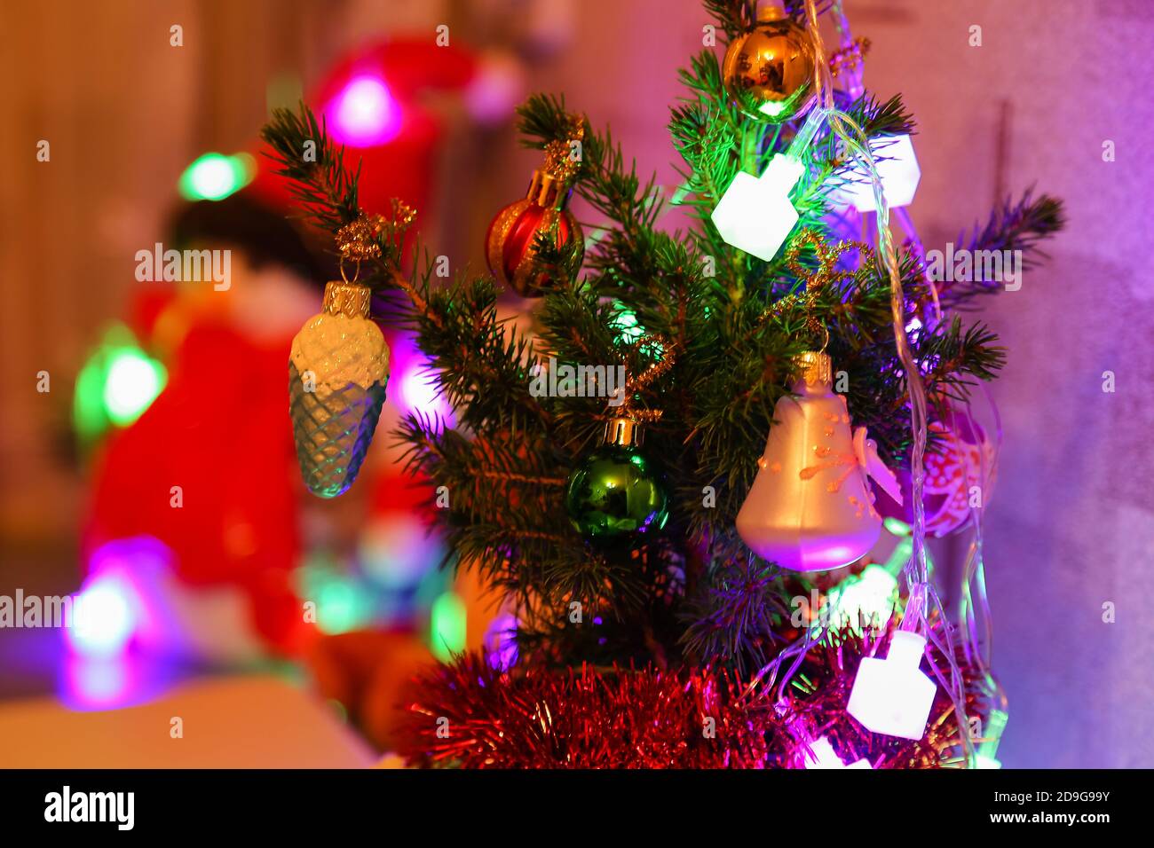Decorated small real Christmas tree at home. Christmas decorations and  toys. New Year atmosphere. Holiday background Stock Photo - Alamy