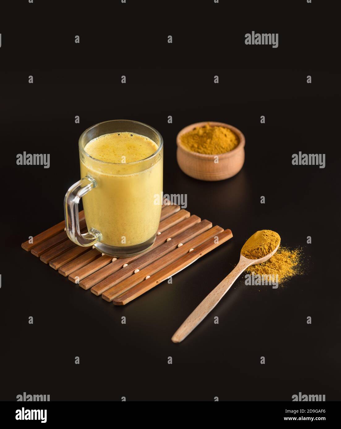 Glass Cup with healthy Indian drink Golden milkturmeric latte mixed