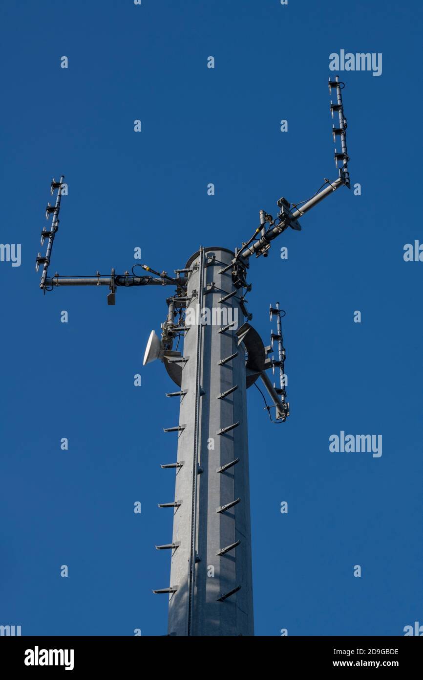 a mobile phone or telecommunications tower or mast against a blue sky with room for copy. Stock Photo