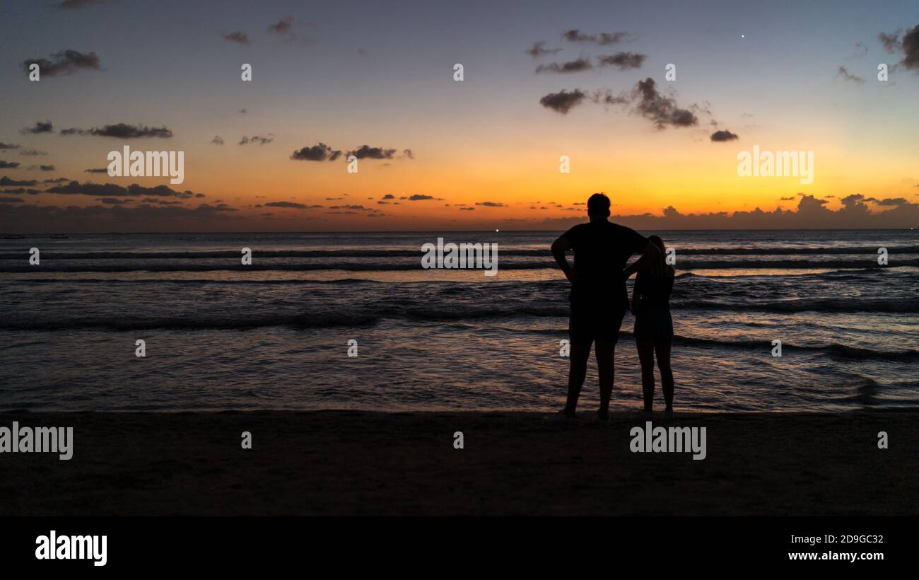 couple walking on the beach at sunset, A silhouette of a couple on the ...