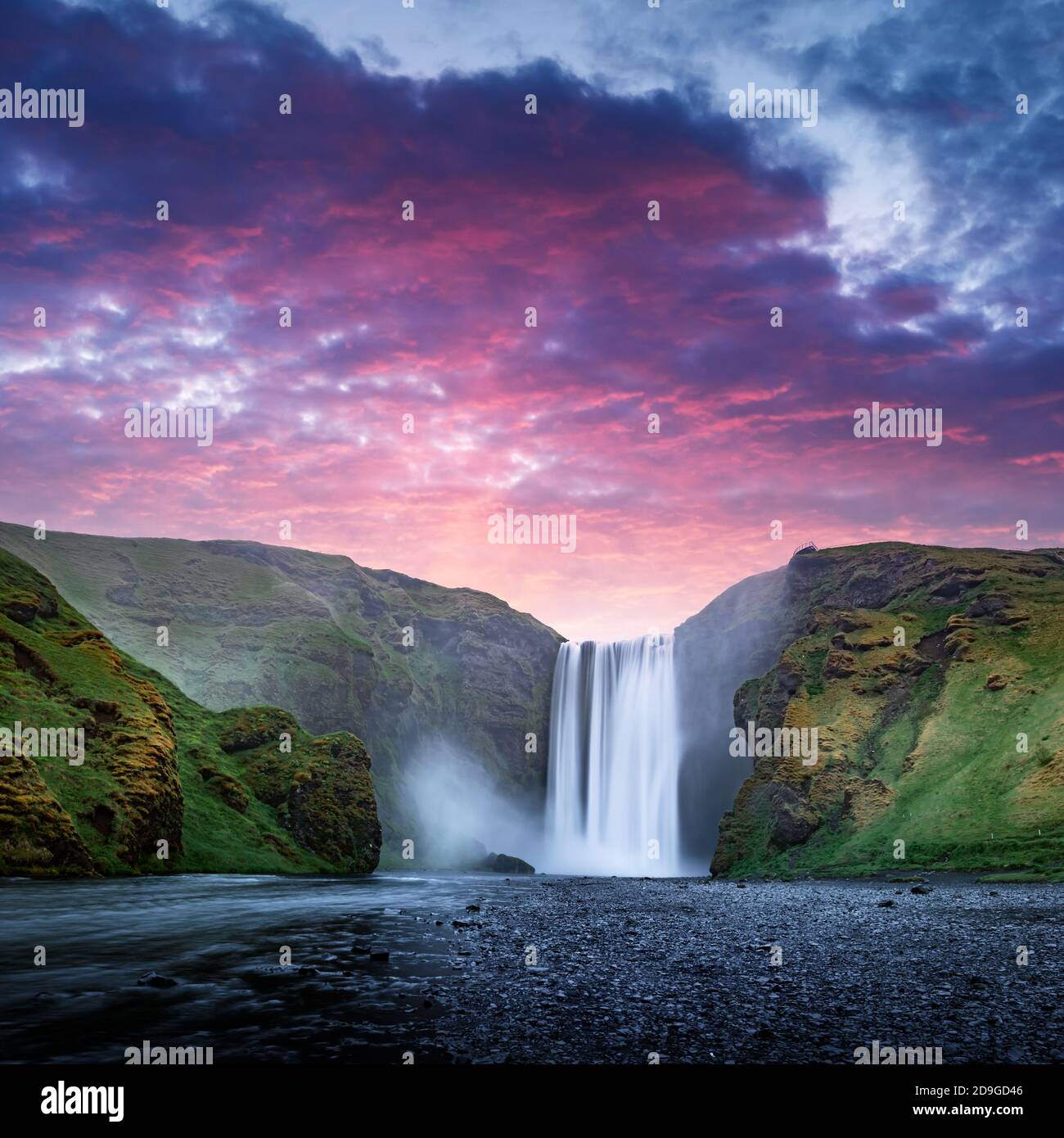 Famous Skogafoss waterfall on Skoga river in sunset time. Iceland, Europe. Great purple sky glowing on background. Landscape photography Stock Photo