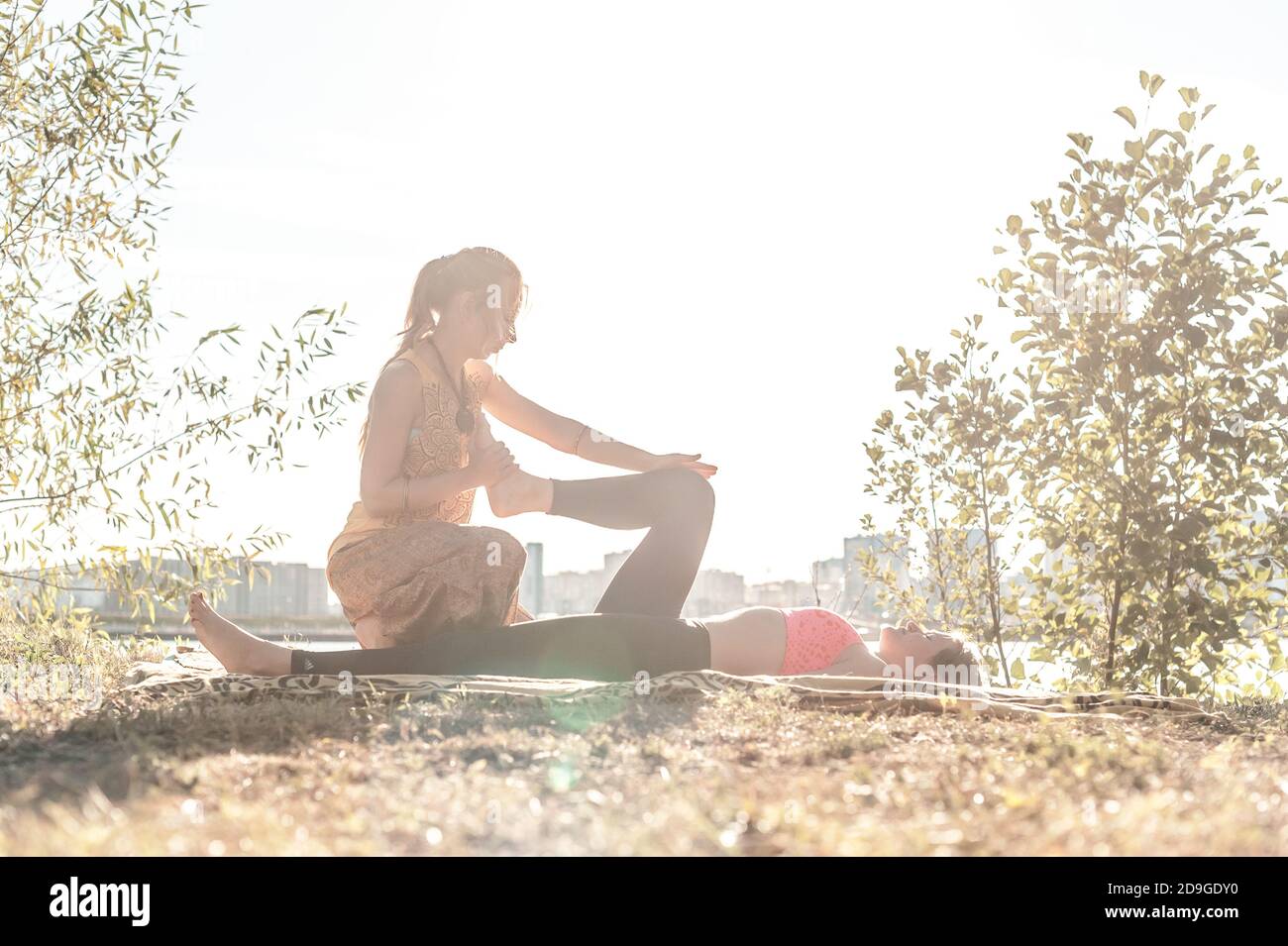 Expert masseuse demonstrates refreshing massaging methods on the grass. Stock Photo