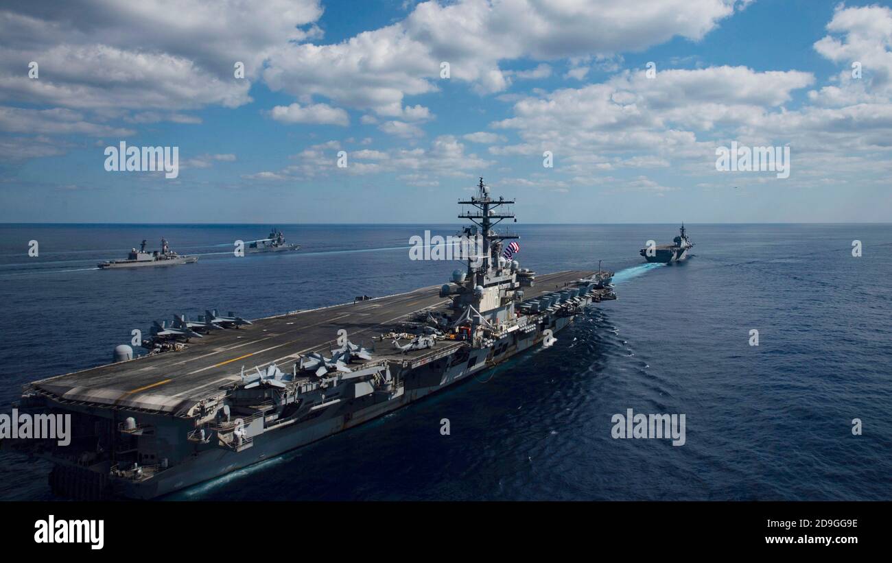 The U.S. Navy nuclear aircraft carrier USS Ronald Reagan joins ships of Japan Maritime Self-Defense Force as they sail in formation during exercise Keen Sword 21 October 26, 2020 in the Philippine Sea. Stock Photo