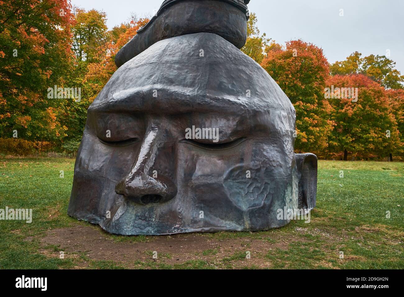 A closeup of the head in Zhang Huan's Three Legged Buddha sculpture. During autumn, peak fall color at Storm King Art Center in New York. Stock Photo