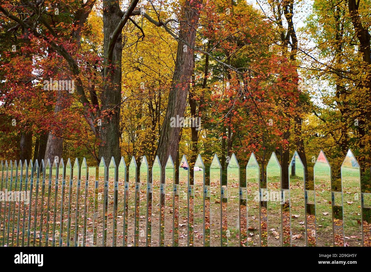 Alyson Shotz's Mirror Fence sculpture, a play on the traditional white picket fence style. During autumn, peak fall color at Storm King Art Center in Stock Photo