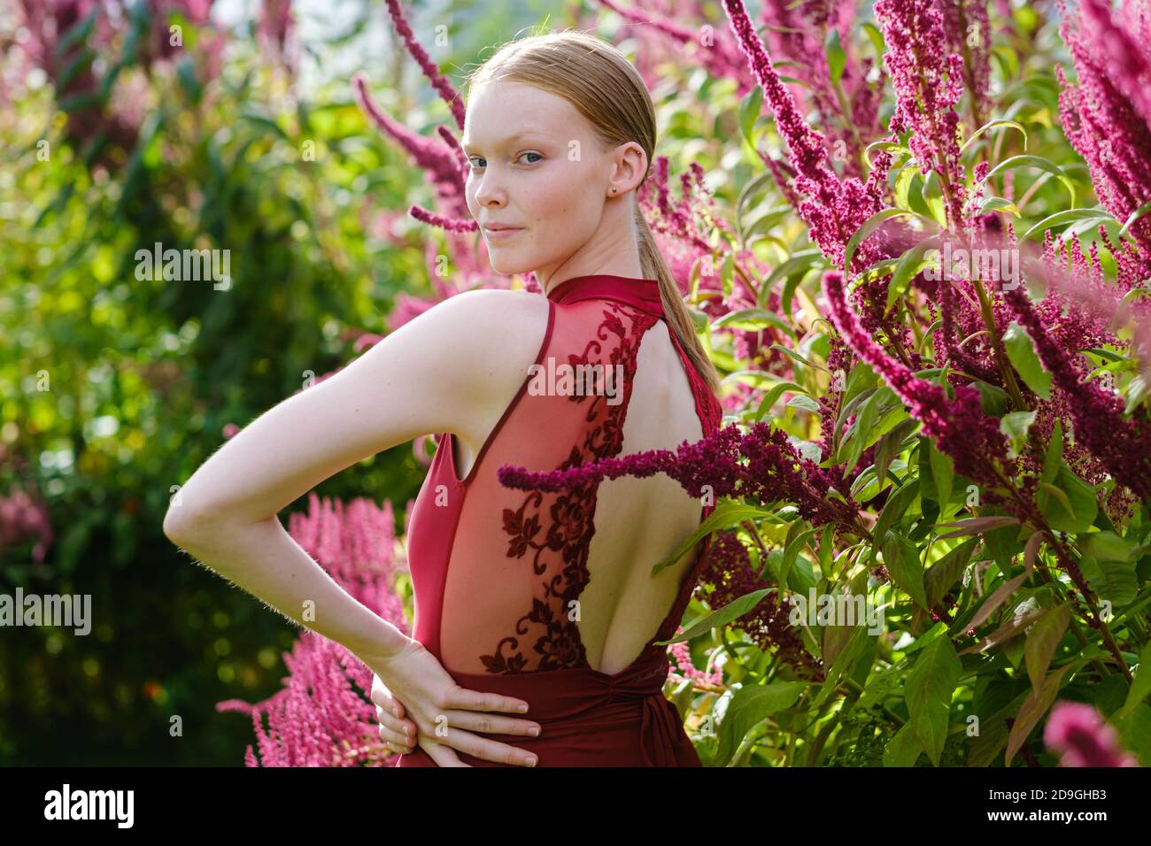 Young Caucasian female ballet dancer posing in burgundy costume Stock Photo