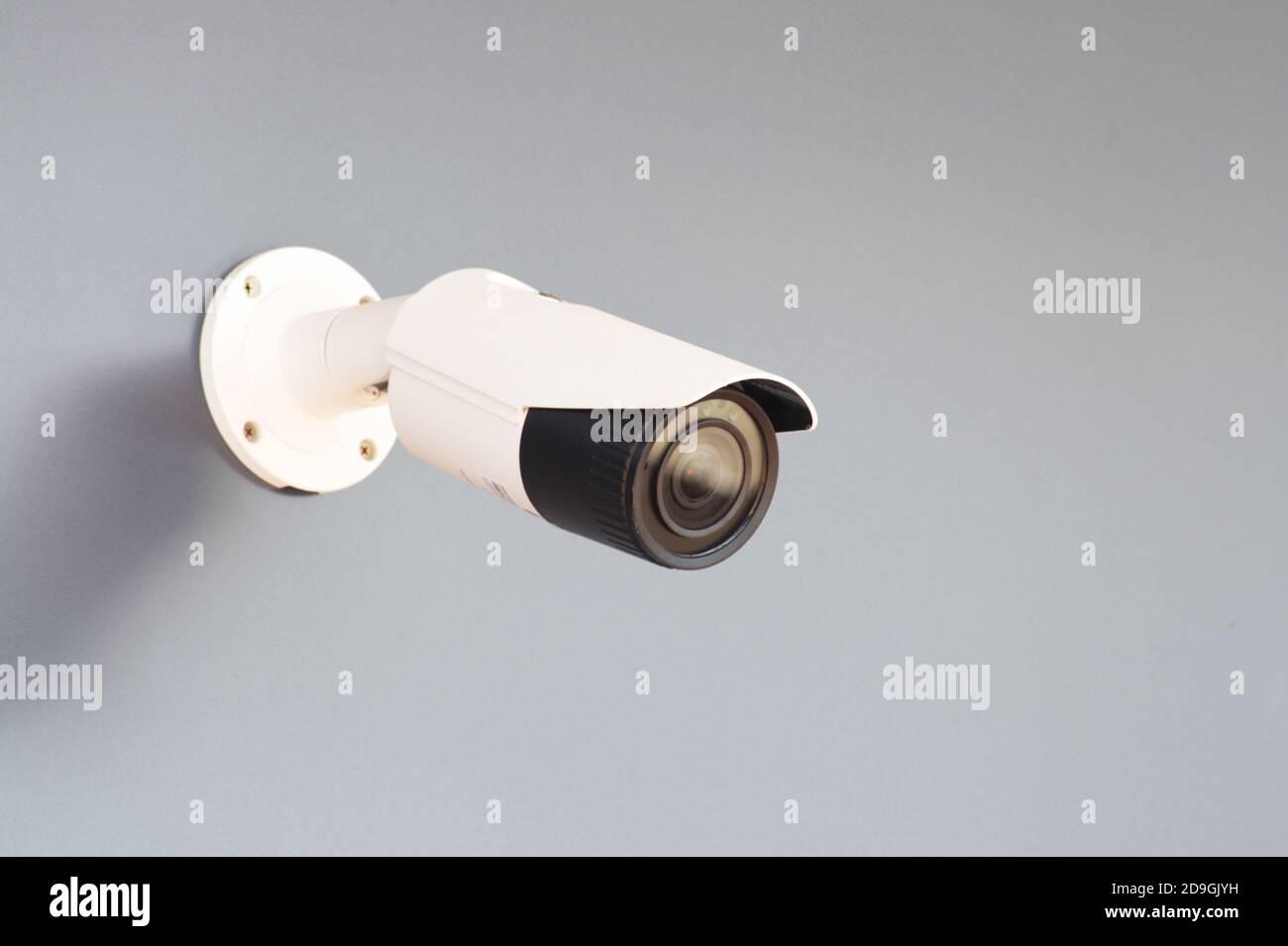 IP CCTV white camera installed on a gray wall - home security system concept Stock Photo