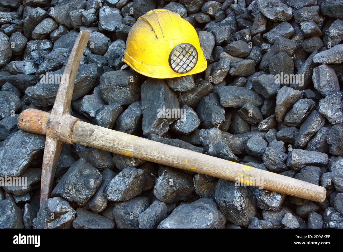 Pickaxe, mining helmet in the background heap of coal Stock Photo - Alamy