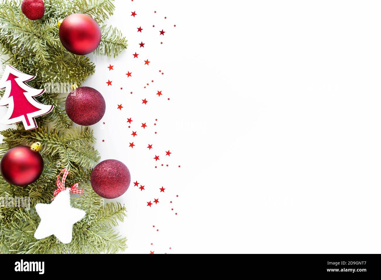 Christmas composition with decoration. Christmas balls, wooden tree, star, fir branches on white surface. Flat lay, top view, copy space Stock Photo