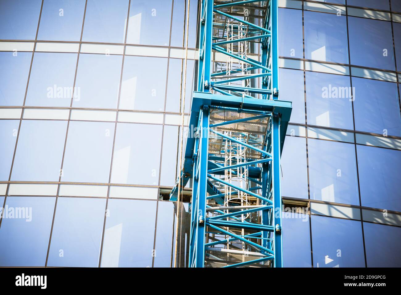 Low angle shot of a modern building under construction with a crane's ...