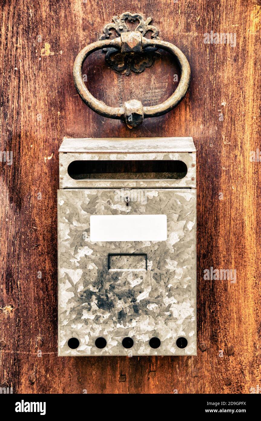 Vertical shot of an old rusty mailbox on a wooden door Stock Photo