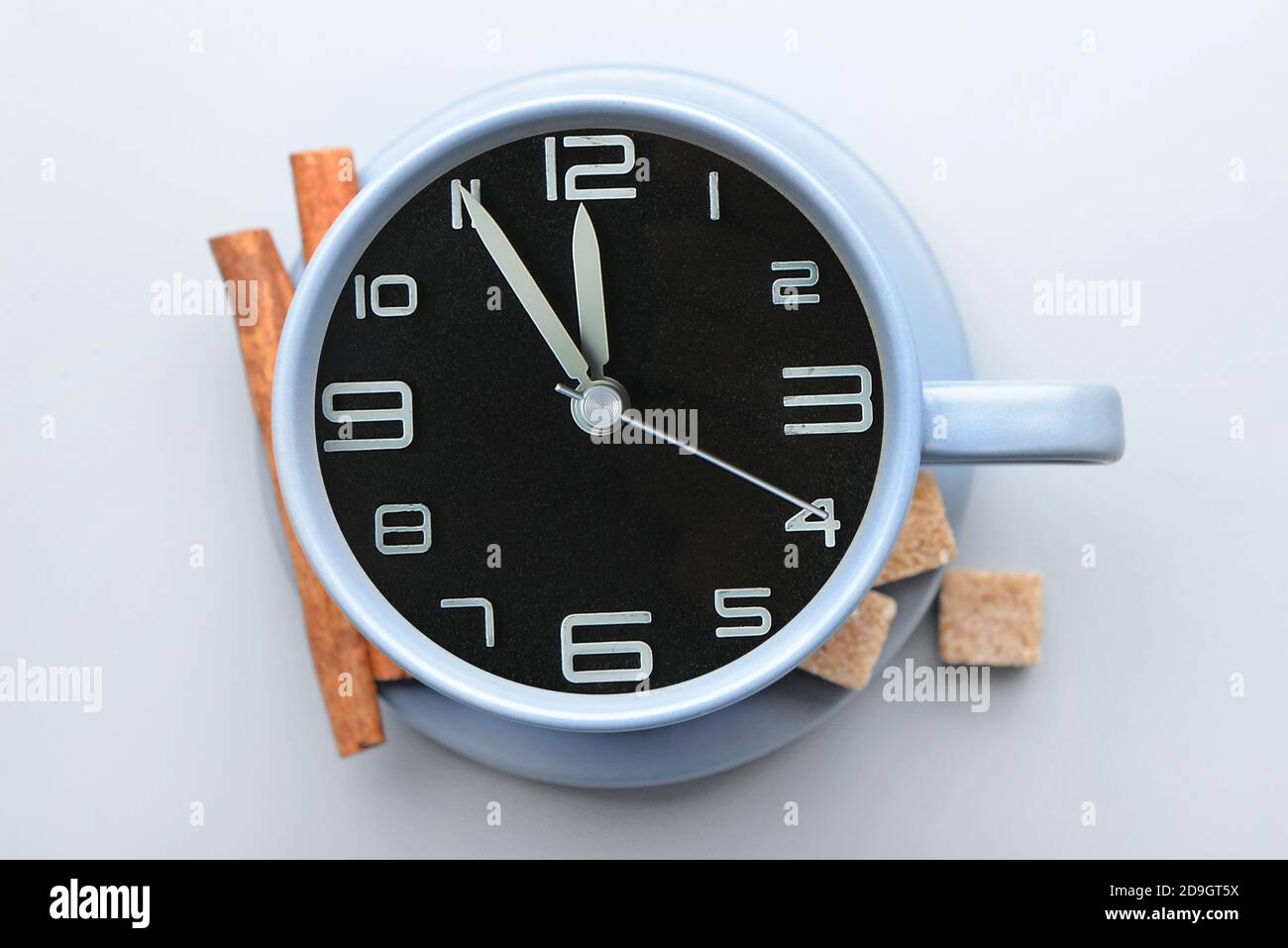 Cup with clock on light background Stock Photo