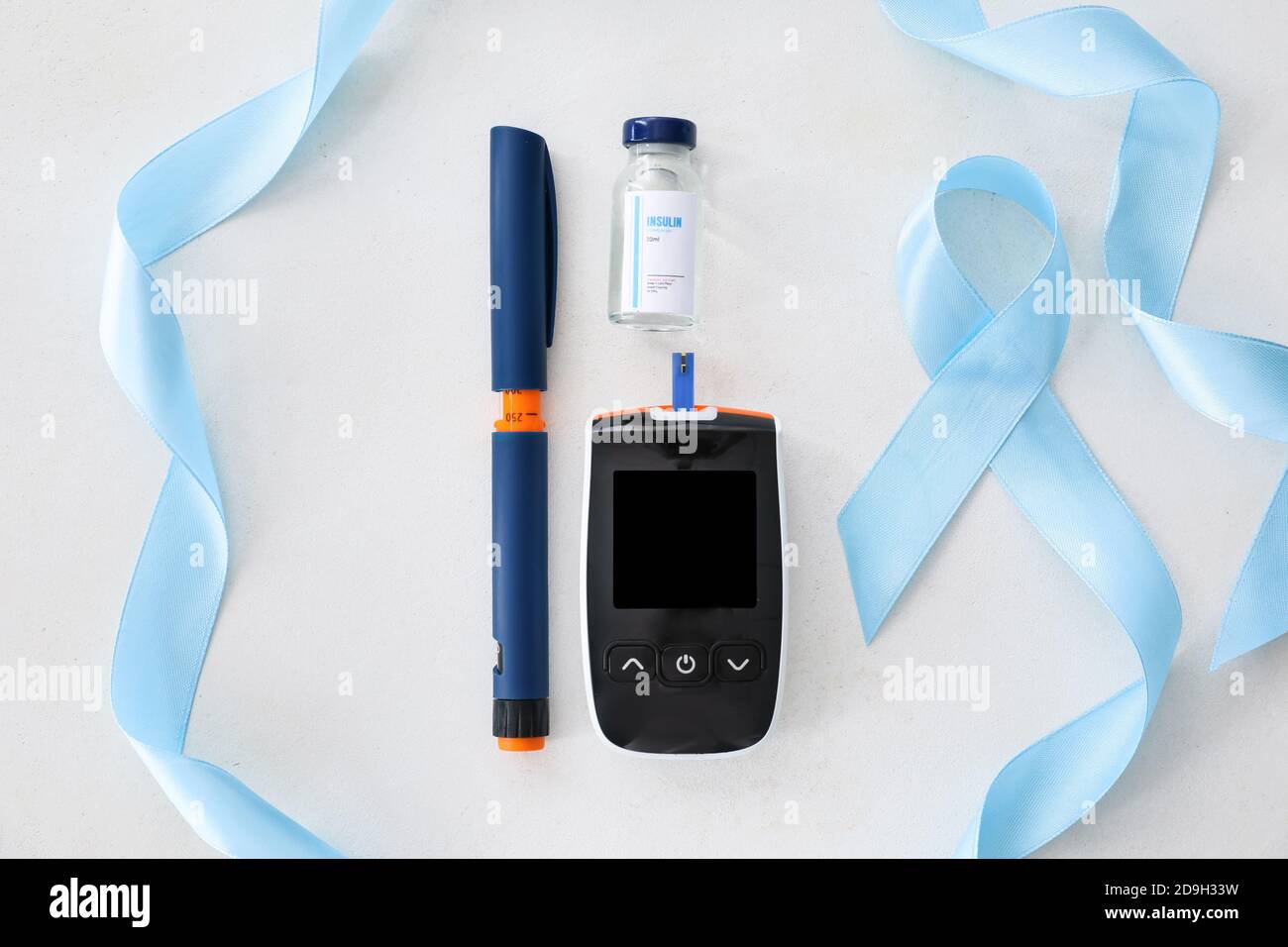 Awareness ribbon with glucometer, insulin and syringe on white ...