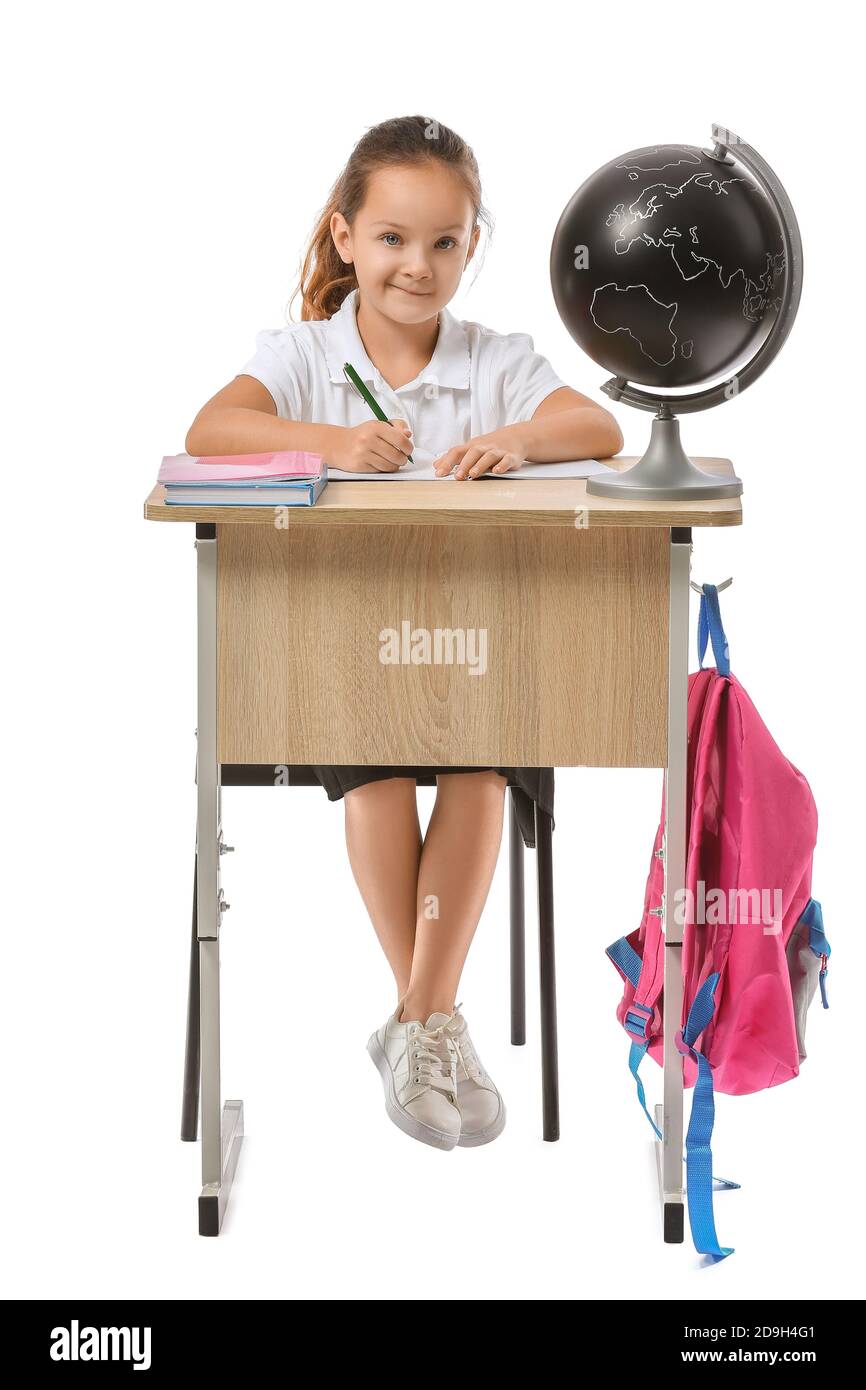 Little pupil sitting at school desk against white background Stock Photo
