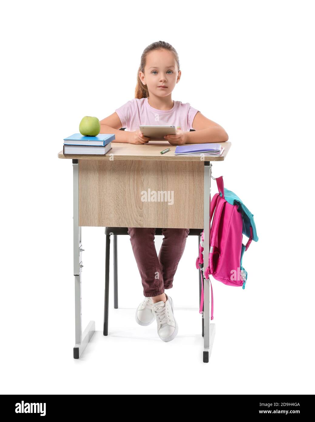 Little pupil sitting at school desk against white background Stock Photo