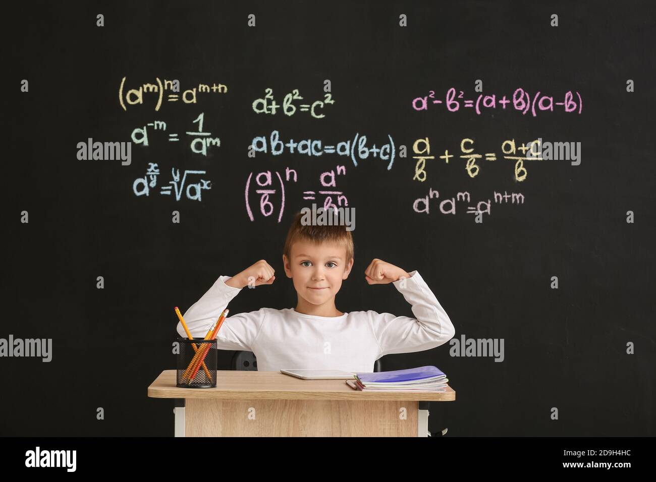 Cute pupil sitting at desk during lesson in classroom Stock Photo - Alamy