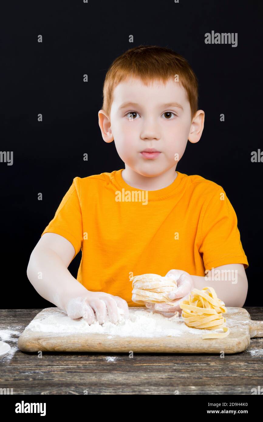 baby boy in the kitchen while helping with cooking Stock Photo Alamy