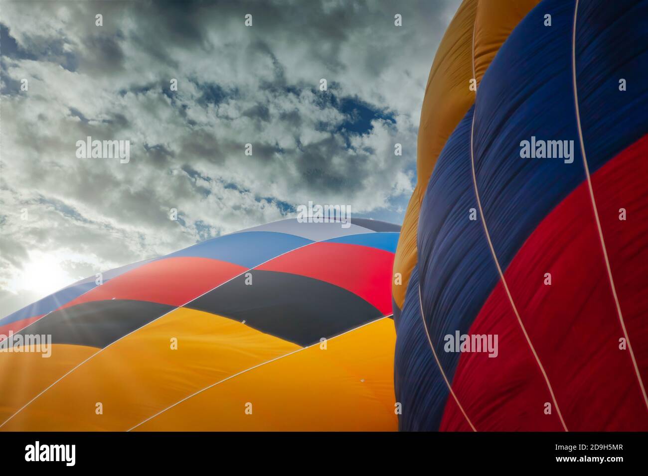 two multicolored balloons against cloudy skies Stock Photo
