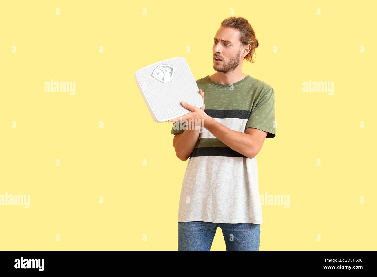 Man with sudden weight loss problem holding measuring scales on color