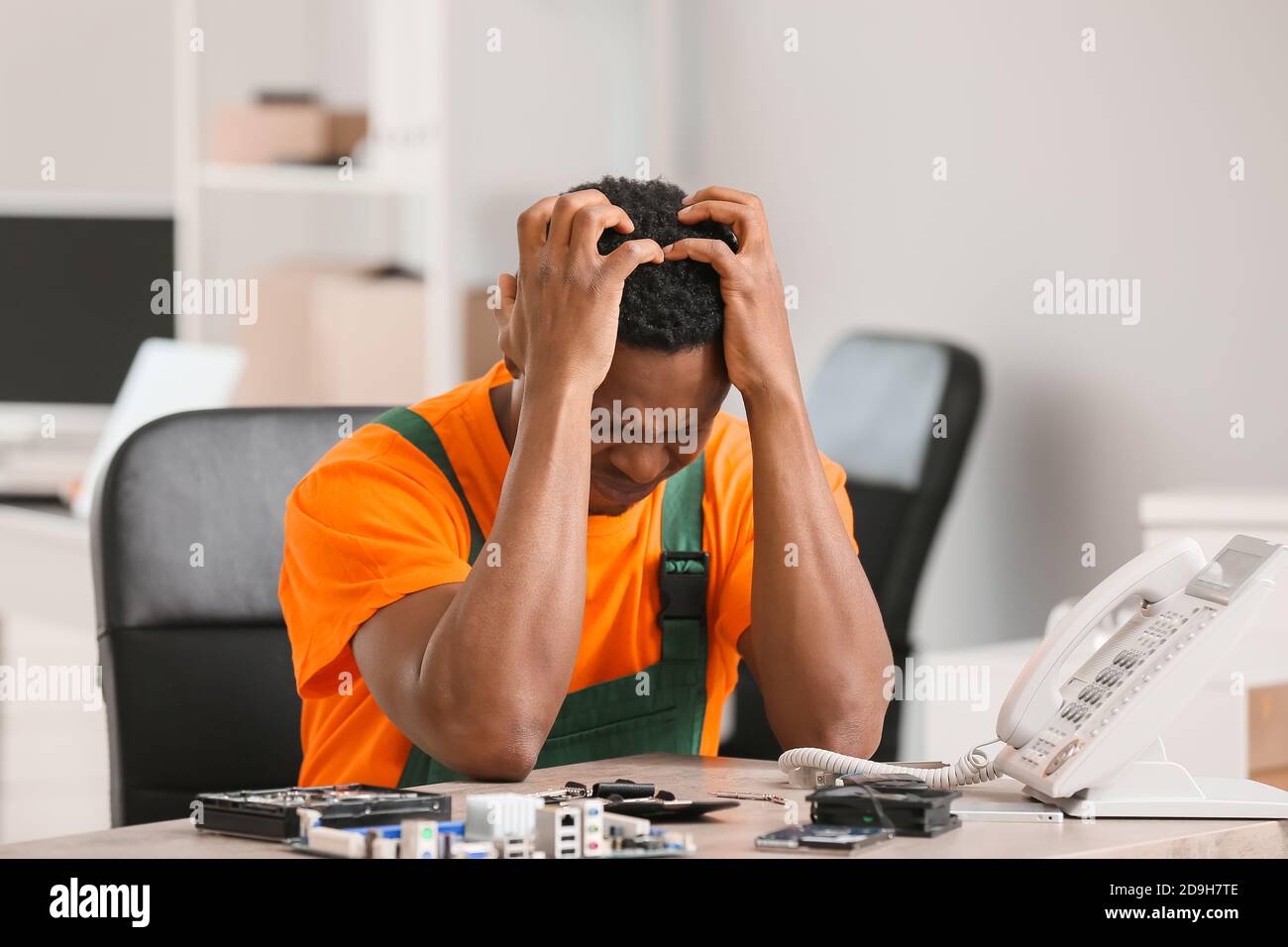 Stressed technician repairing PC in service center Stock Photo