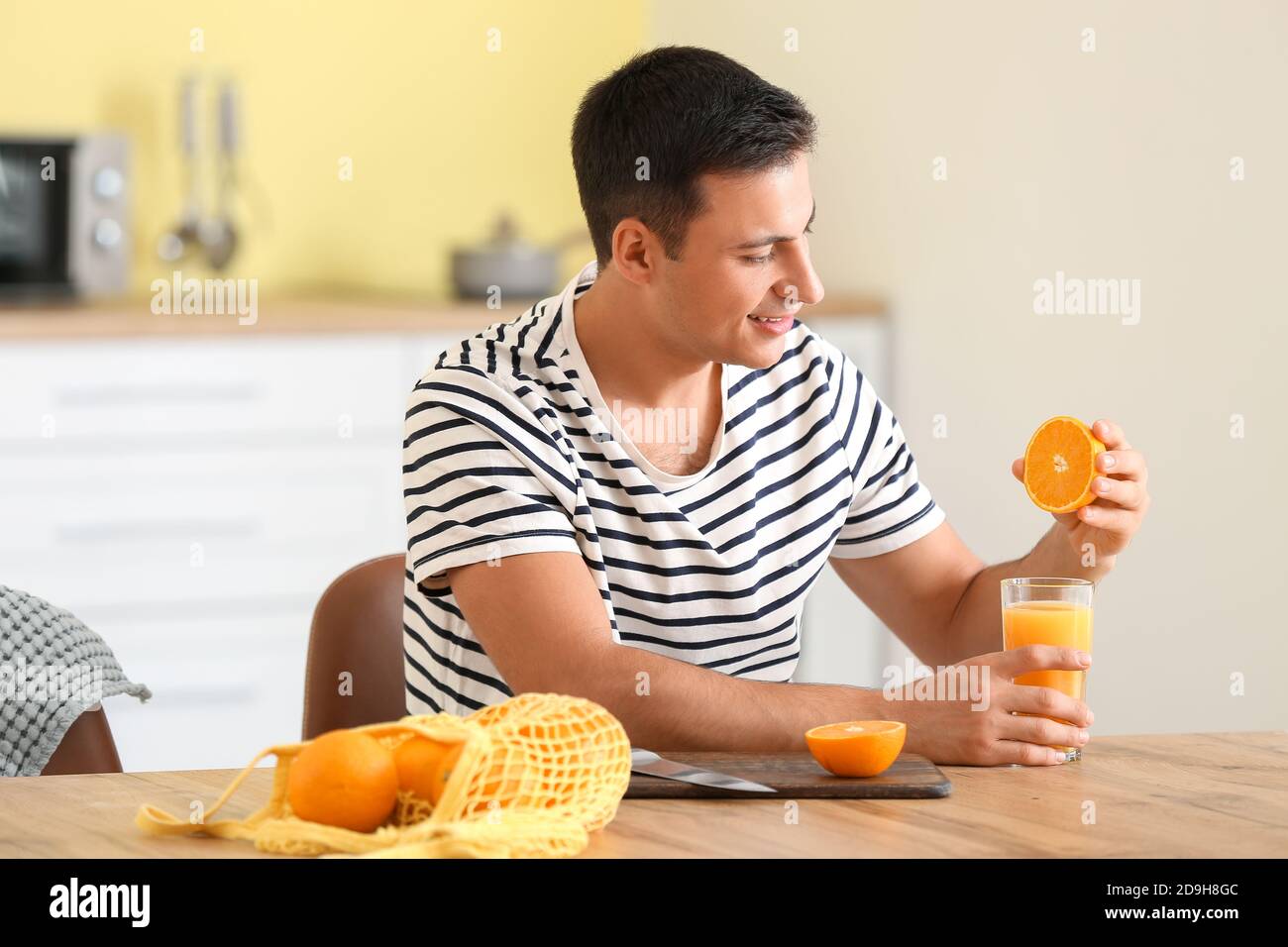 Female hand squeezing orange juice from fresh oranges with a juicer in the  home kitchen, ?lose up Stock Photo - Alamy