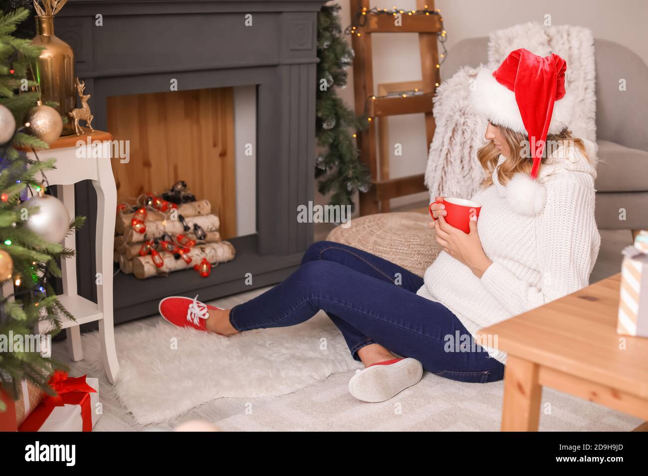 Beautiful pregnant woman drinking cacao at home on Christmas eve Stock
