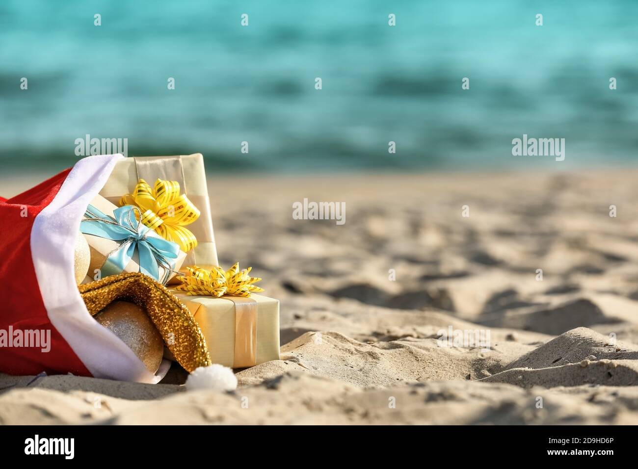 Santa Claus bag with gifts on beach Stock Photo - Alamy