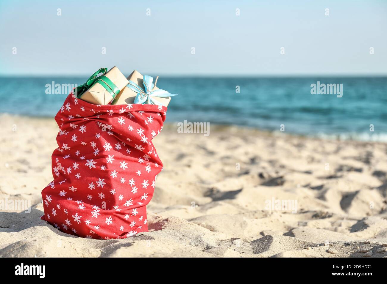 Santa Claus bag with gifts on beach Stock Photo - Alamy