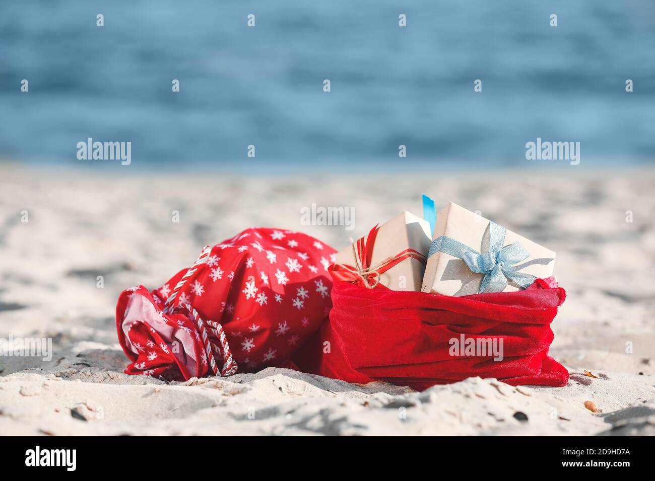 Santa Claus bags with gifts on beach Stock Photo - Alamy