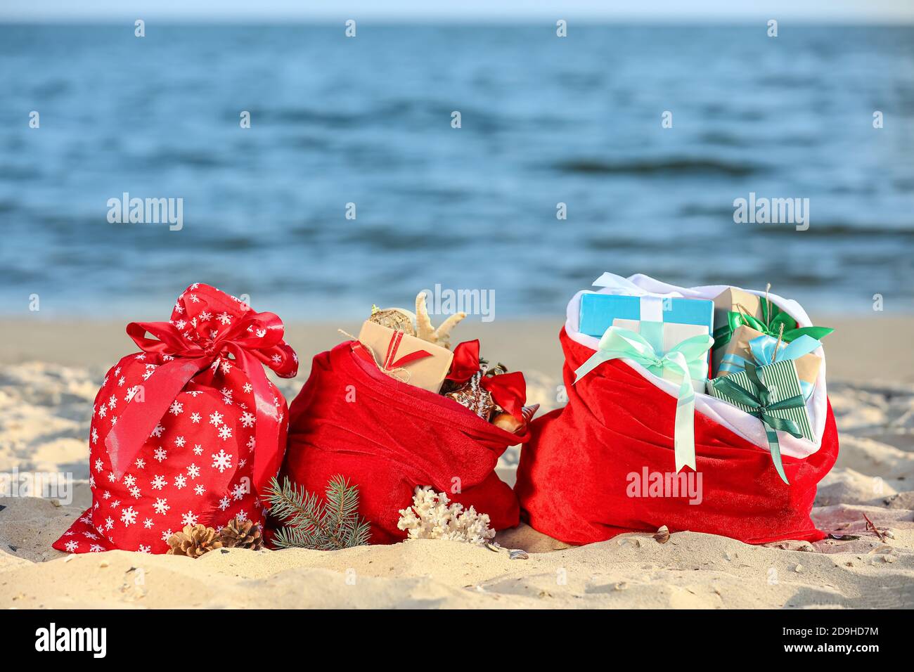 Santa Claus bags with gifts on beach Stock Photo - Alamy