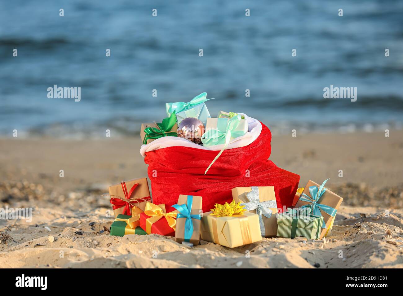 Santa Claus bag with gifts on beach Stock Photo - Alamy