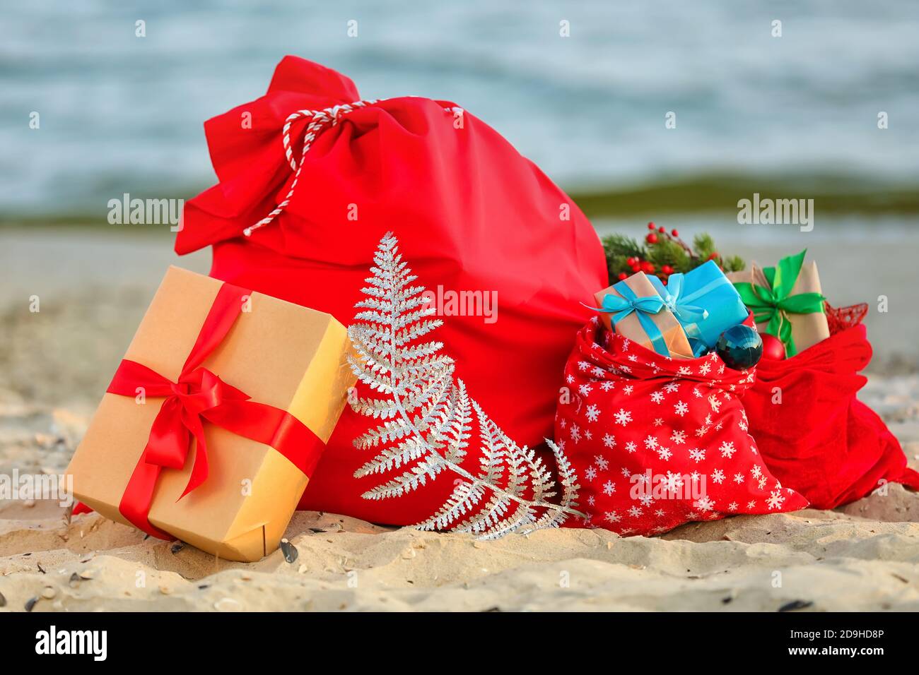 Santa Claus bags with gifts on beach Stock Photo - Alamy