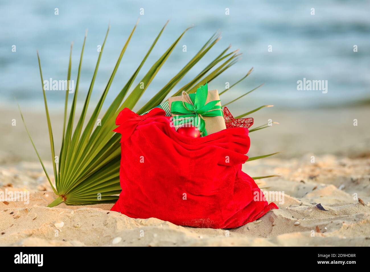 Santa Claus bag with gifts on beach Stock Photo - Alamy
