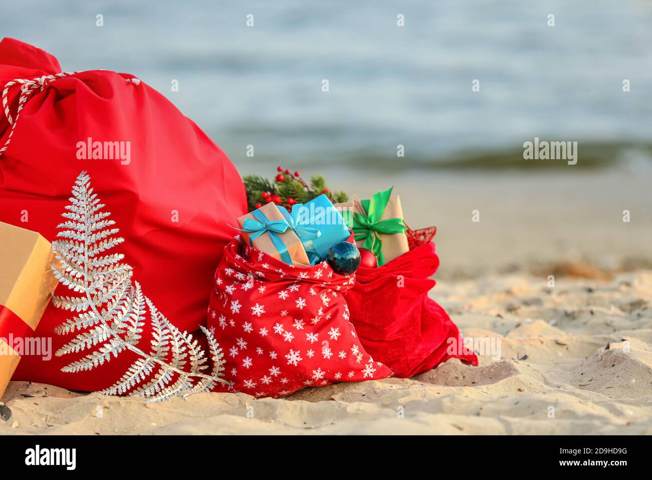 Santa Claus bags with gifts on beach Stock Photo - Alamy