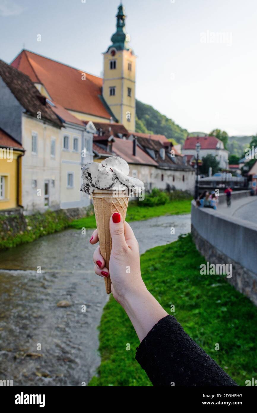 Vertical shot of a female hand holding ice cream in a waffle cone Stock ...