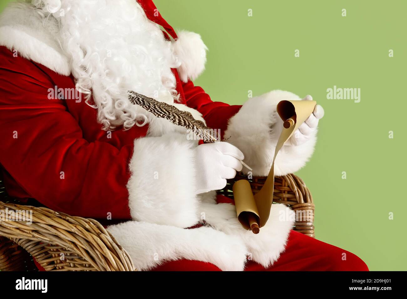 Santa Claus writing letter on color background Stock Photo - Alamy