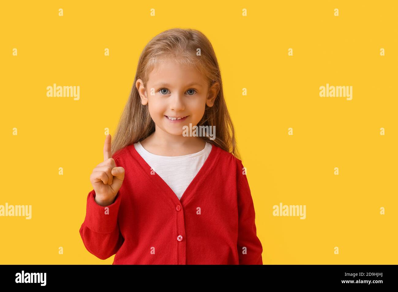 Cute little girl with raised index finger on color background Stock ...