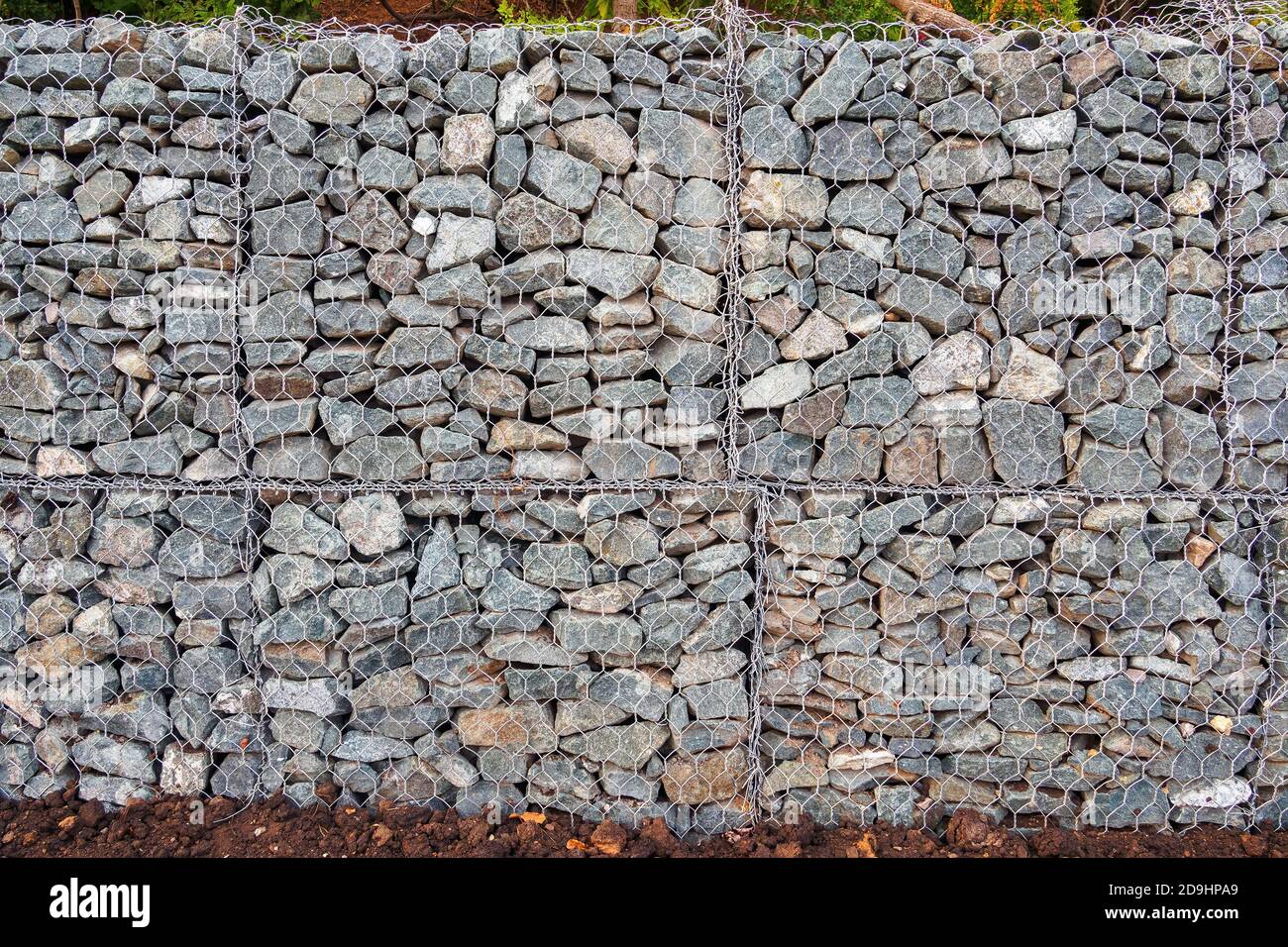Mesh and stone fence, gabion for use in civil engineering, road building, military applications and landscaping. Stock Photo