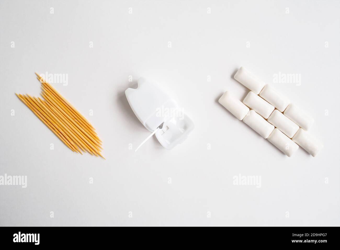 top view of toothpicks, chewing gums and health dental floss on white