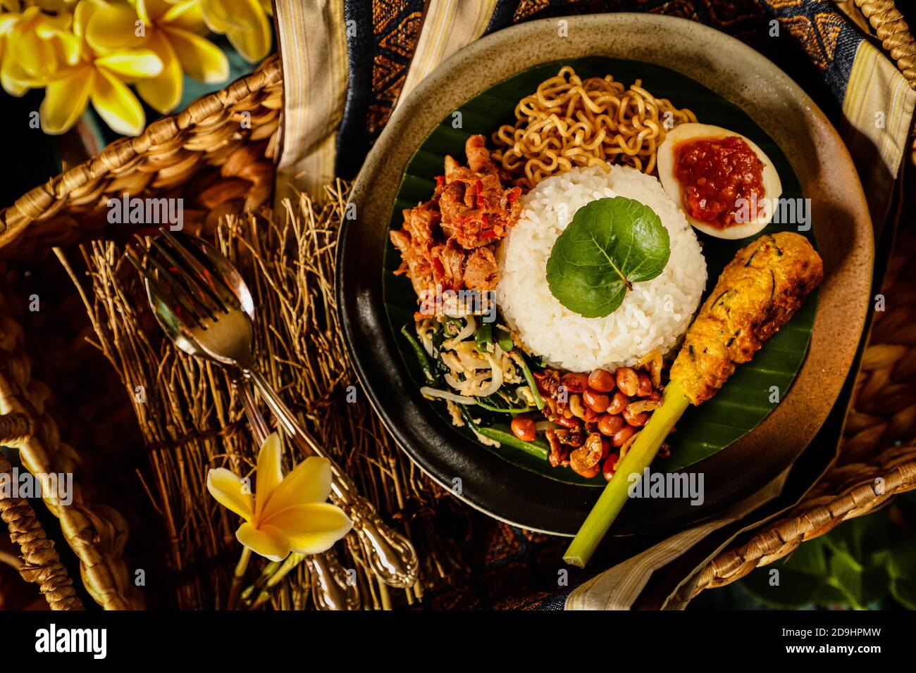 Nasi Campur Bali. Balinese meal of rice with shredded chicken, vegetable salad, peanuts, satay