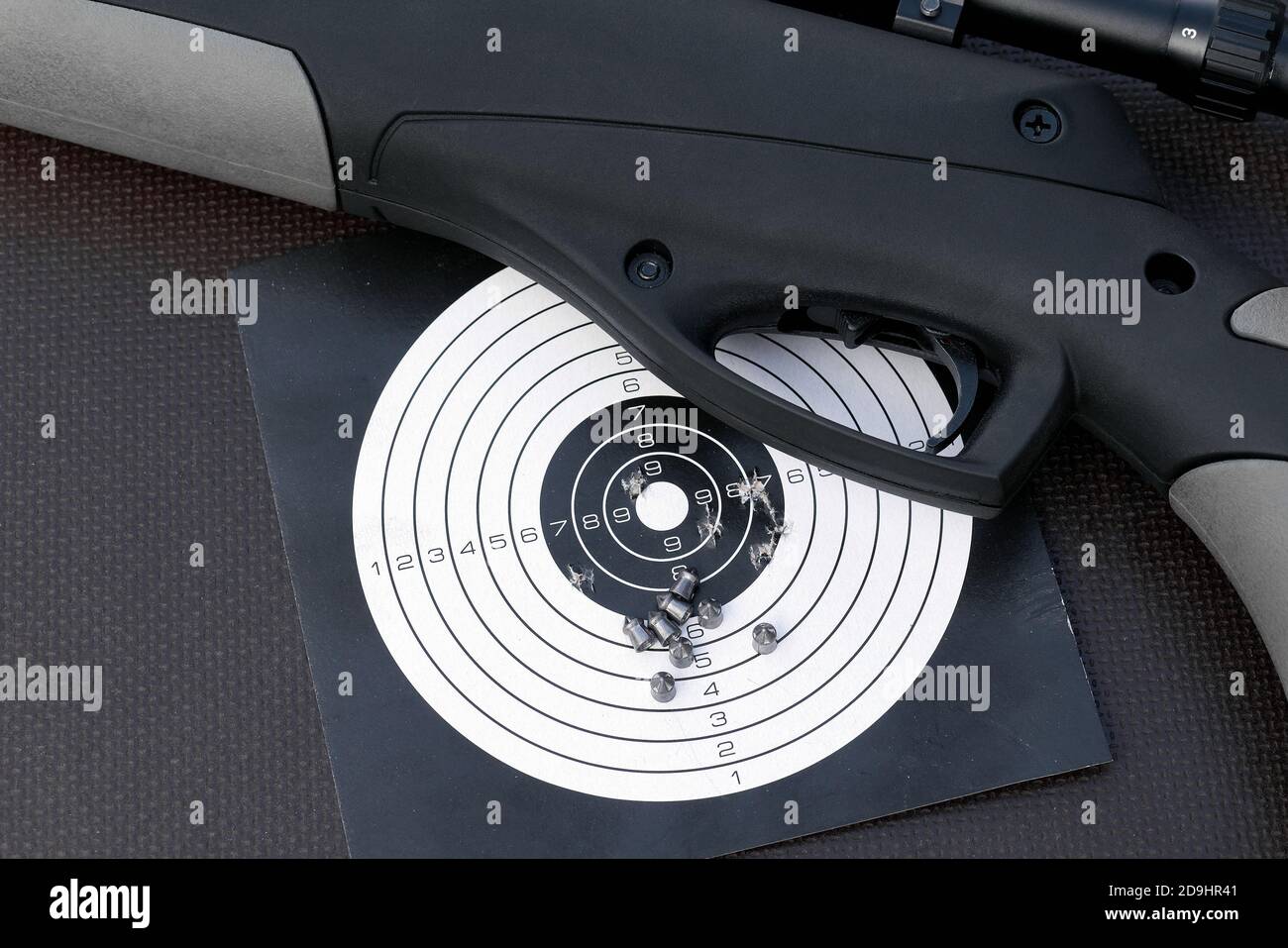 top view of air gun, paper shooting target with bullet holes and airgun pellets Stock Photo