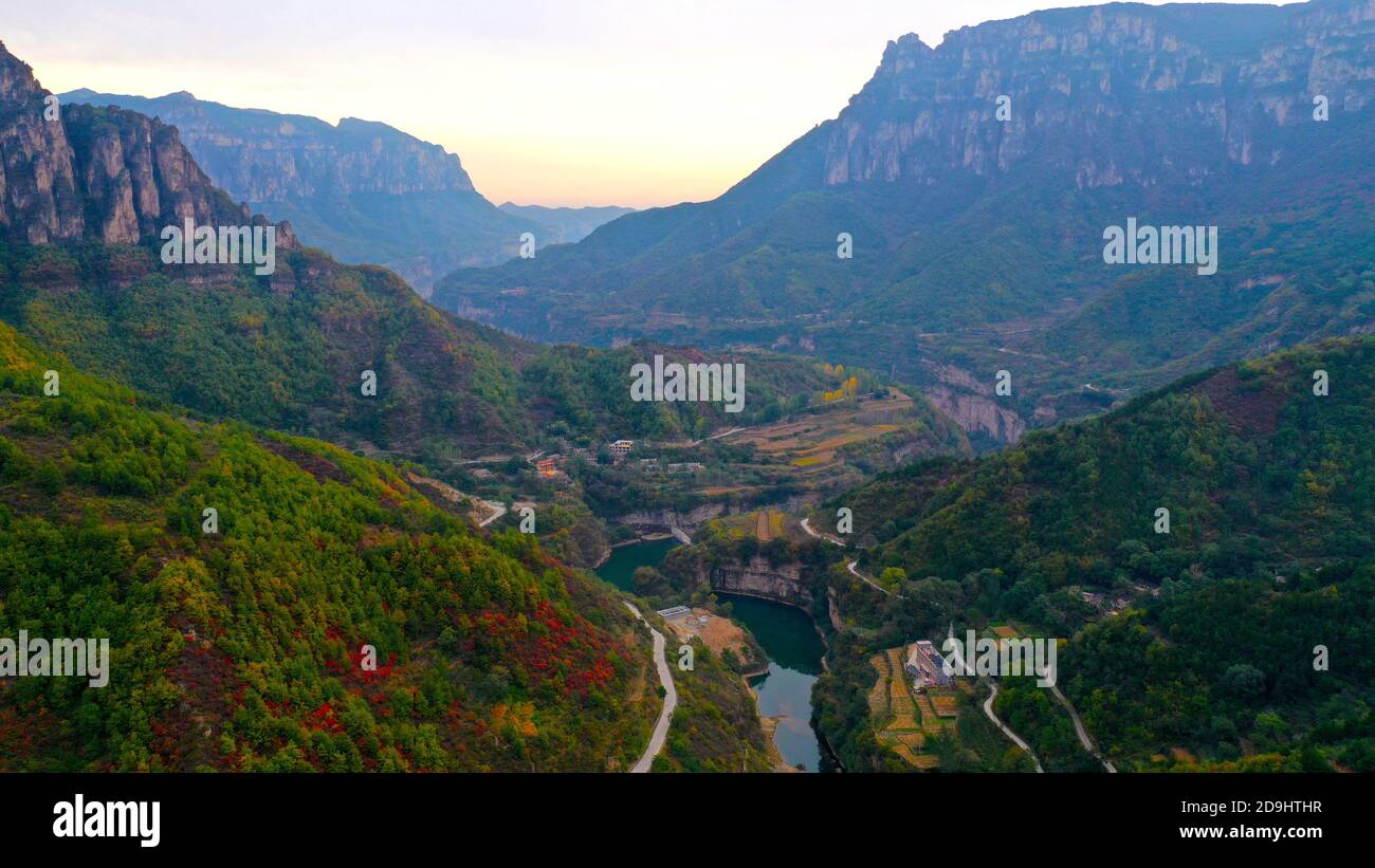 An aerial view of Taihang Mountains, a Chinese mountain range running down the eastern edge of the Loess Plateau, with trees becoming either red and y Stock Photo
