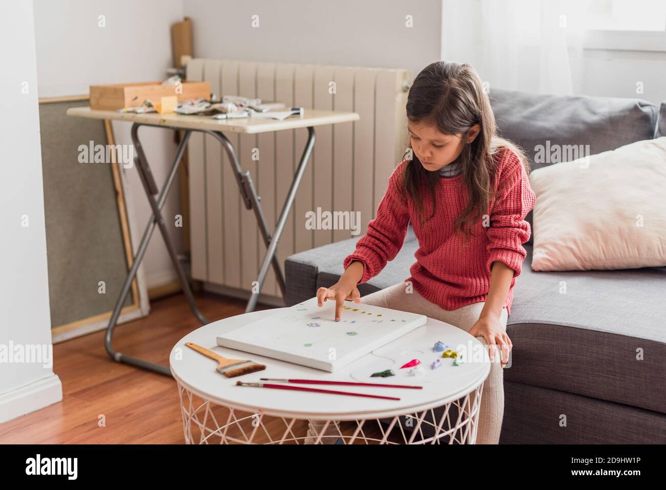 Hispanic little girl doing art class at home learning from home